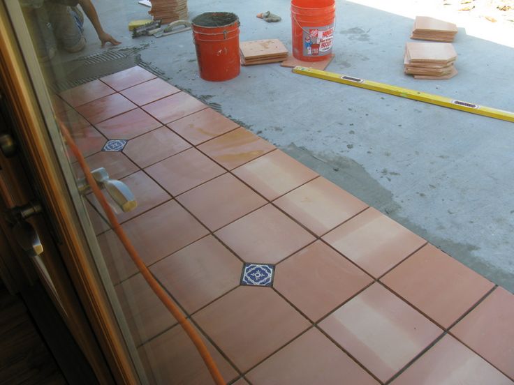 the tile is being laid out on the floor in front of the building's glass door