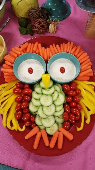 an owl made out of vegetables and carrots on a plate with other food items