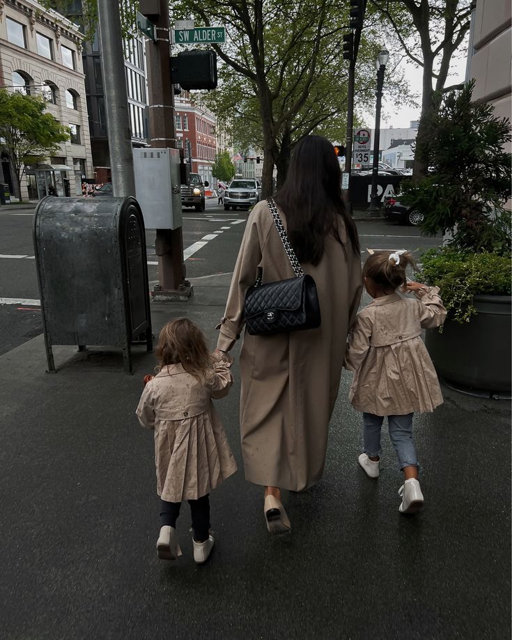 a woman and two children walking down the street