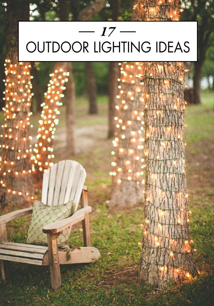 a white chair sitting next to a tree covered in lights