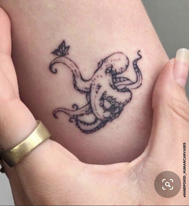 an octopus tattoo is shown on the side of a woman's stomach, which has been drawn in black ink