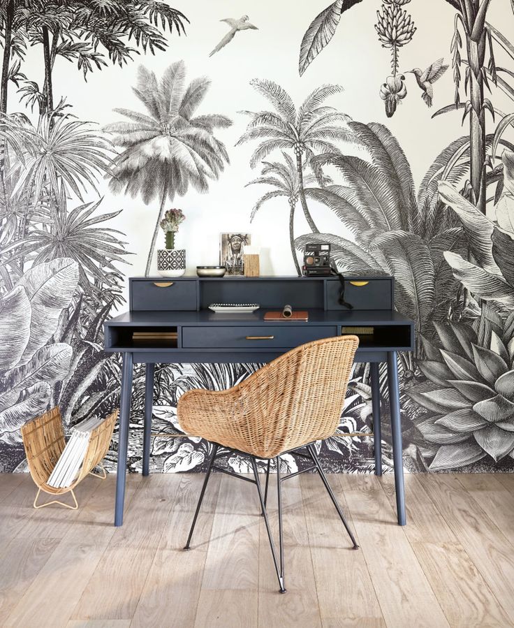 a desk with two chairs in front of a wallpapered jungle scene on the wall