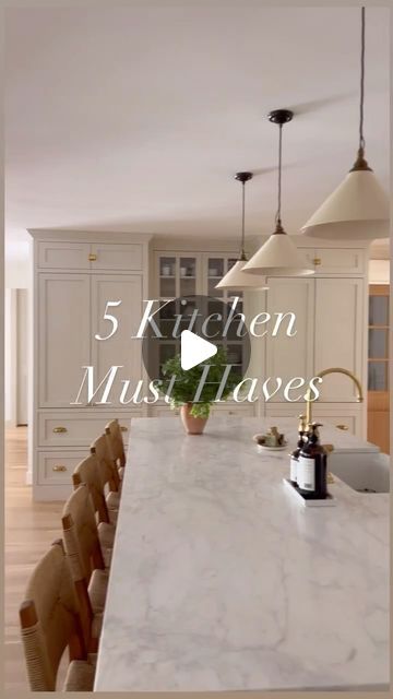 a kitchen with marble counter tops and wooden chairs in front of an island that is surrounded by white cabinets