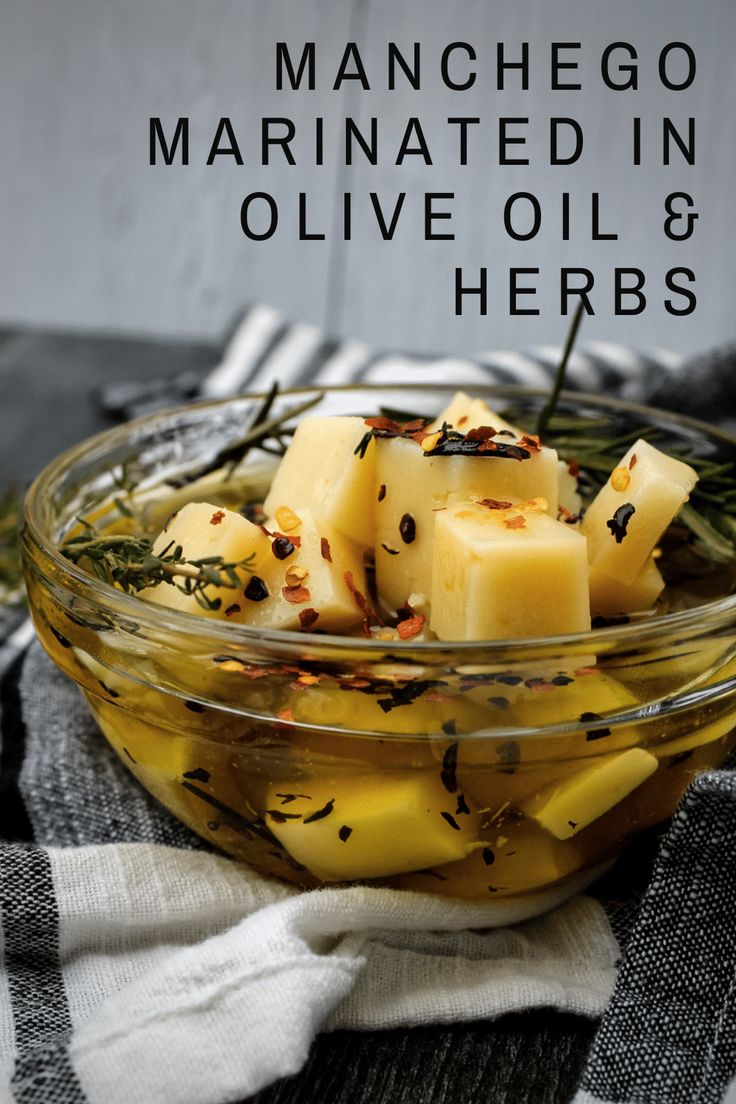 a glass bowl filled with olive oil and herbs