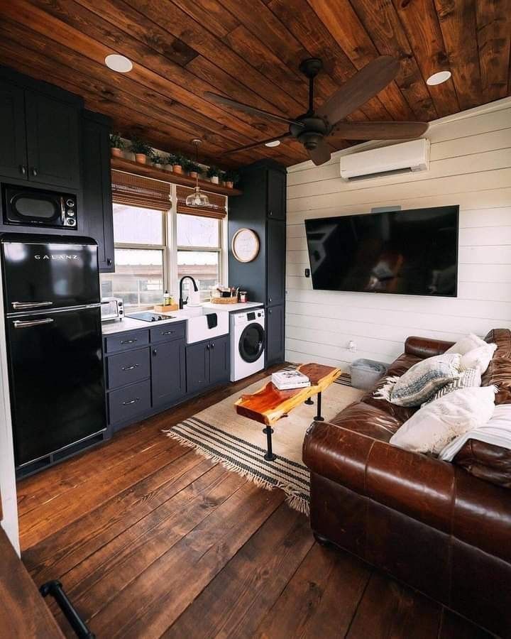 a living room filled with furniture and a flat screen tv mounted to the side of a wall