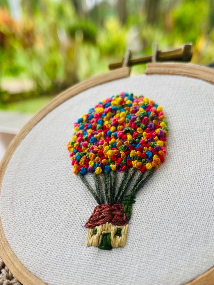 a colorful balloon is in the shape of a house on a white canvas with wood frame