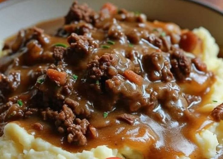 a bowl filled with mashed potatoes covered in meat and gravy