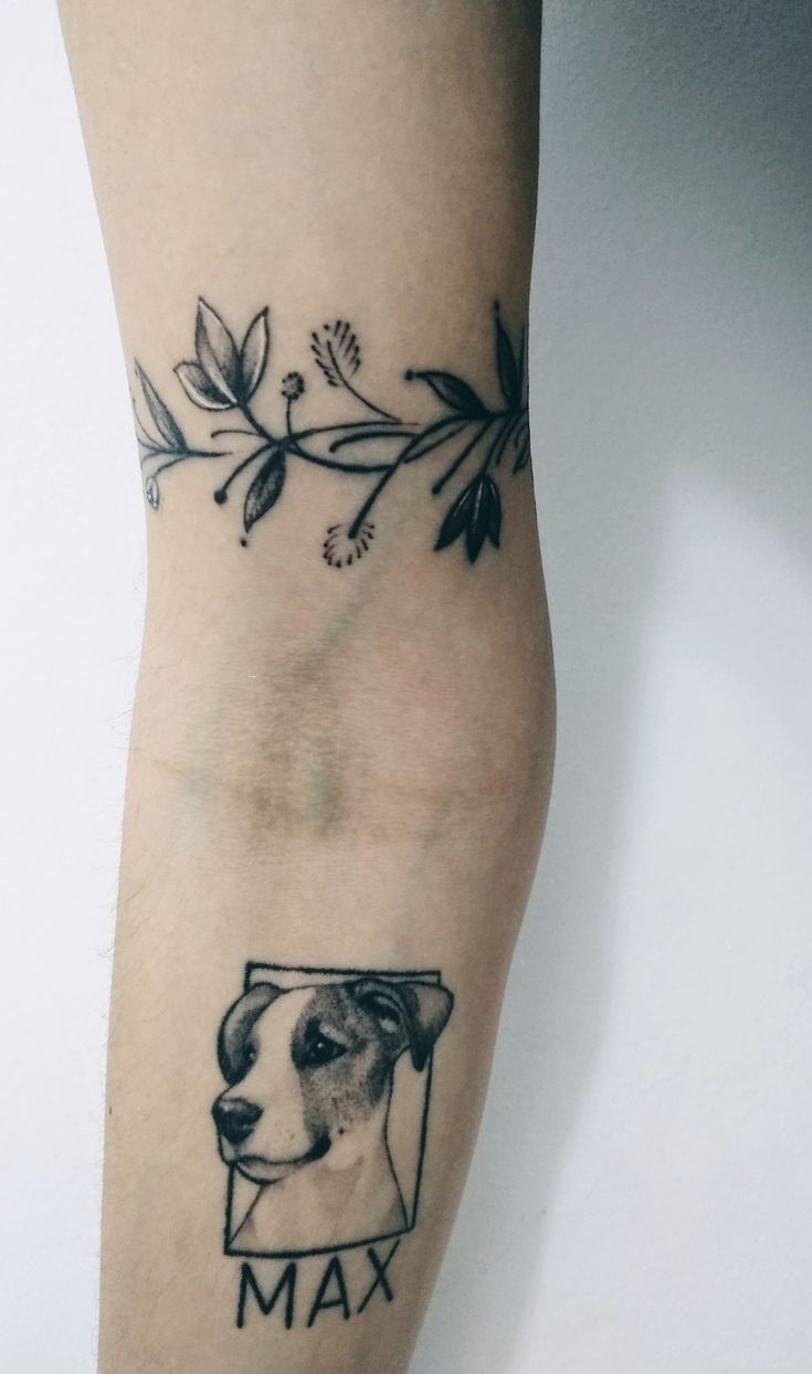 a tattoo on the leg of a person with a dog's head and name