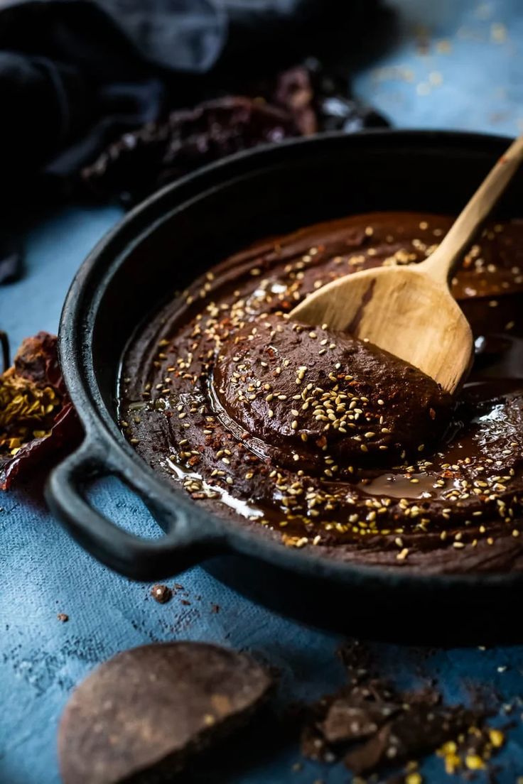 a wooden spoon in a black pan filled with chocolate spread