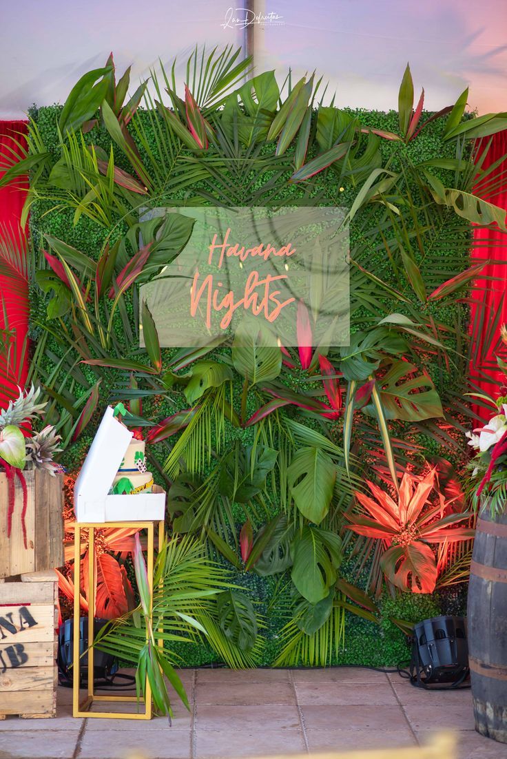 a green wall with plants on it and a sign that says happy nights in front of it