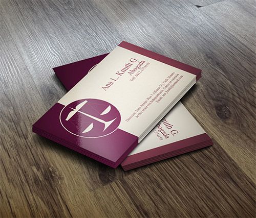 two business cards sitting on top of a wooden floor next to each other, one with a cross in the middle