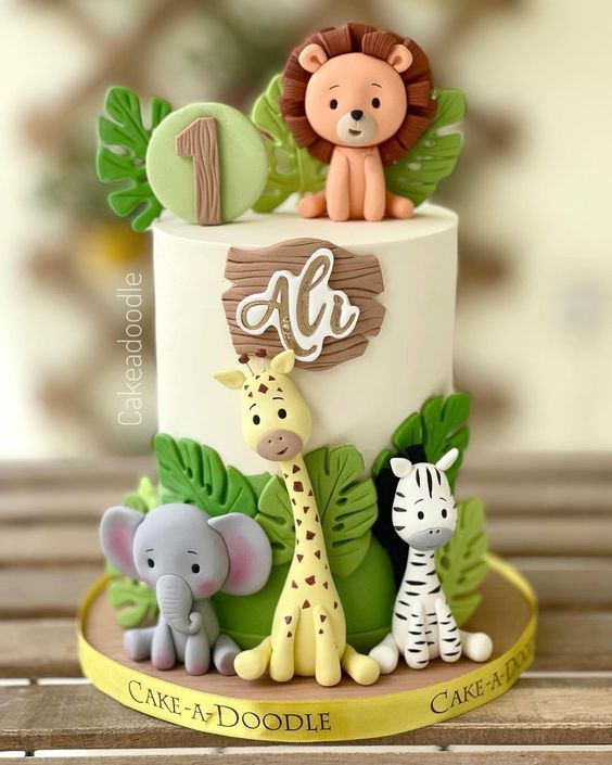 a cake decorated with animals and leaves on a table