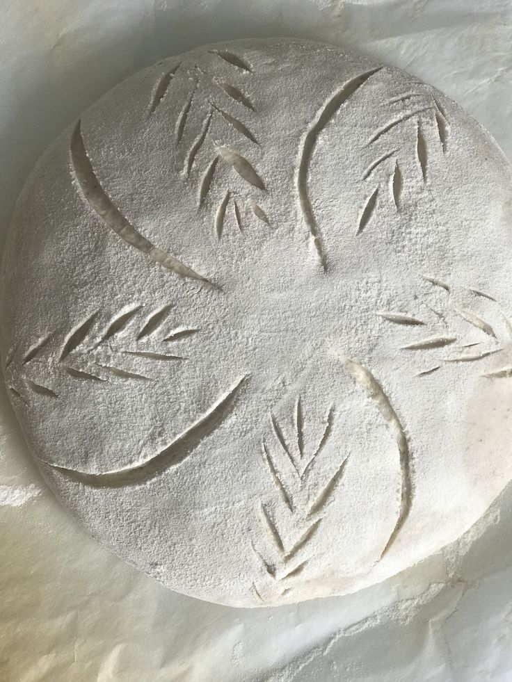 a white circular object with leaves carved on it's side, sitting on a piece of paper