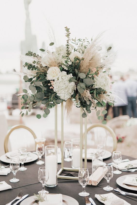 an elegant centerpiece with white flowers and greenery