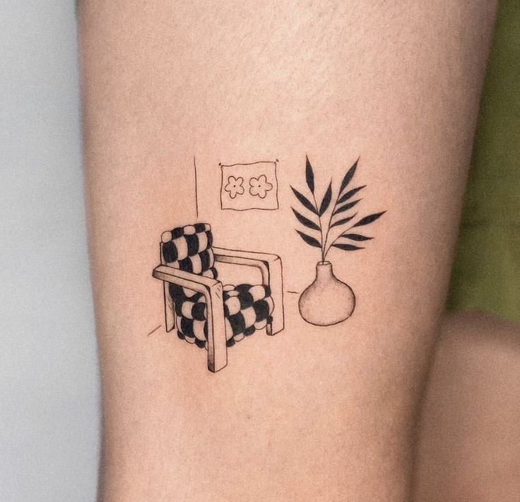 a tattoo on the leg of a woman with a chair and potted plant