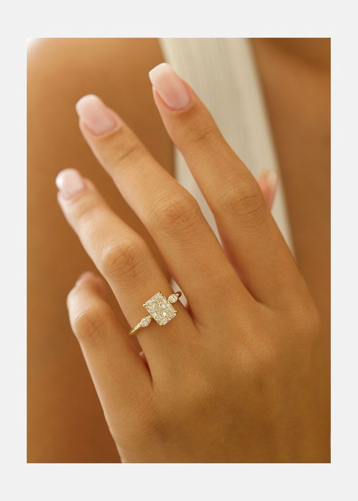 a woman's hand with a diamond ring on it