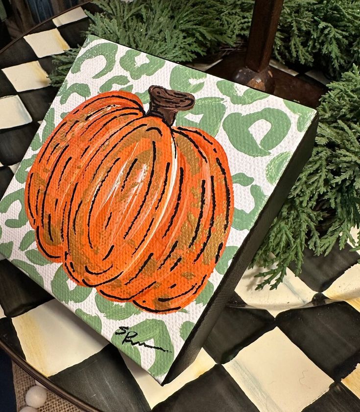 an acrylic painting of a pumpkin on a checkered table