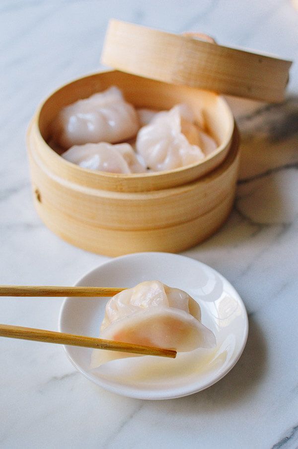 dumplings and chopsticks are sitting on a plate next to a wooden box