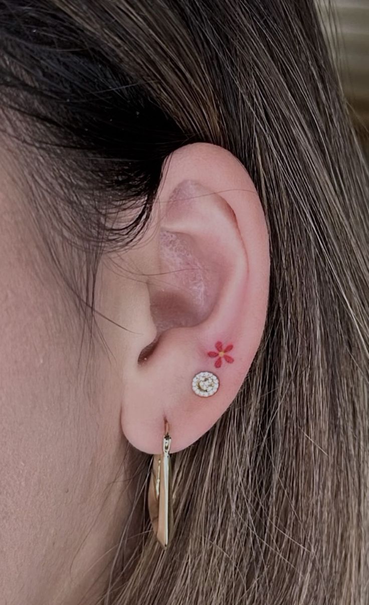 a close up of a person with ear piercings on their ears and behind the ear