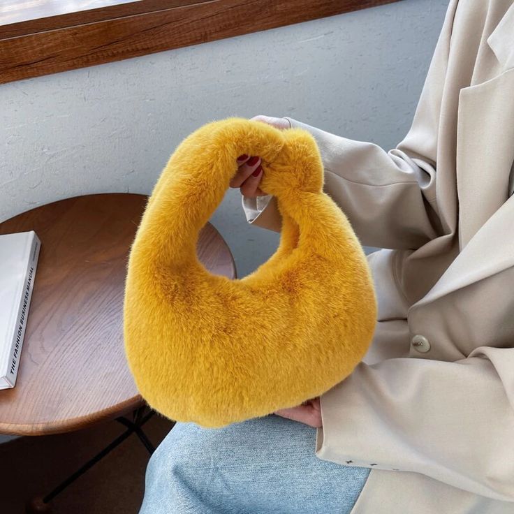 a person sitting on a chair with a fuzzy yellow ring around their neck and hands