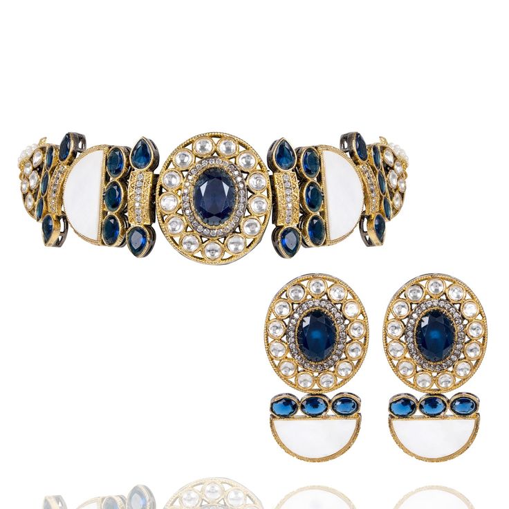 Capture attention and radiate charm effortlessly in every hue! Introducing a mesmerizing blend of mother of pearl, delicately polished sapphire blue stones adorned with sparkling CZ and traditional kundan accents that creates a unique symphony and a harmonious combination of elegance and grace. The set includes a choker and a pair of matching earrings. Approximate earrings length is 1.9". Designed over high-quality brass as base metal with silver and gold plating. In-stock & ready-to-ship. *Plea Wedding Jewelry With Gemstones And Mother Of Pearl, Fusion Style Blue Kundan Jewelry, Traditional Jewelry With Gemstone Accents For Party, Elegant Jeweled Jewelry Sets For Diwali, Elegant Kundan Jewelry Sets With Stones, Elegant Blue Jewelry Sets For Diwali, Elegant Jeweled Sapphire Jewelry, Blue Fusion Style Jewelry For Celebration, Elegant Sapphire Jeweled Jewelry