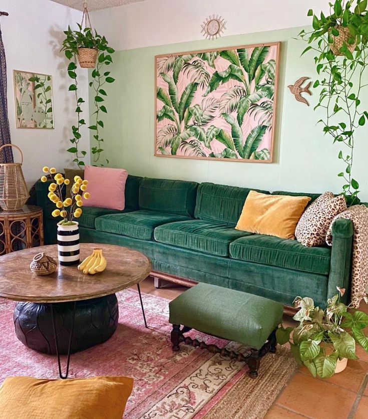 a living room filled with green couches and colorful pillows on top of a rug