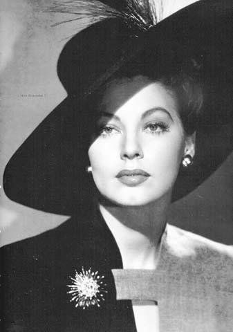 a black and white photo of a woman wearing a hat