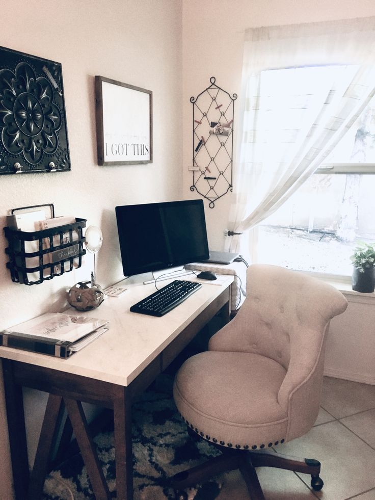 a desk with a computer on top of it next to a chair and window in the corner