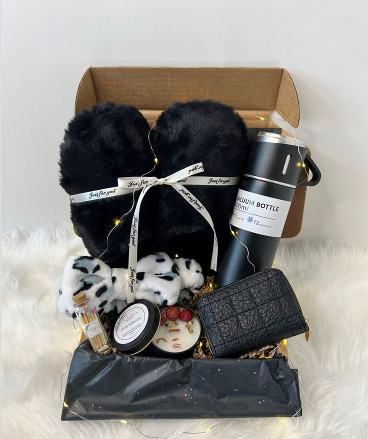 a box filled with black items sitting on top of a white fur covered floor next to a cup