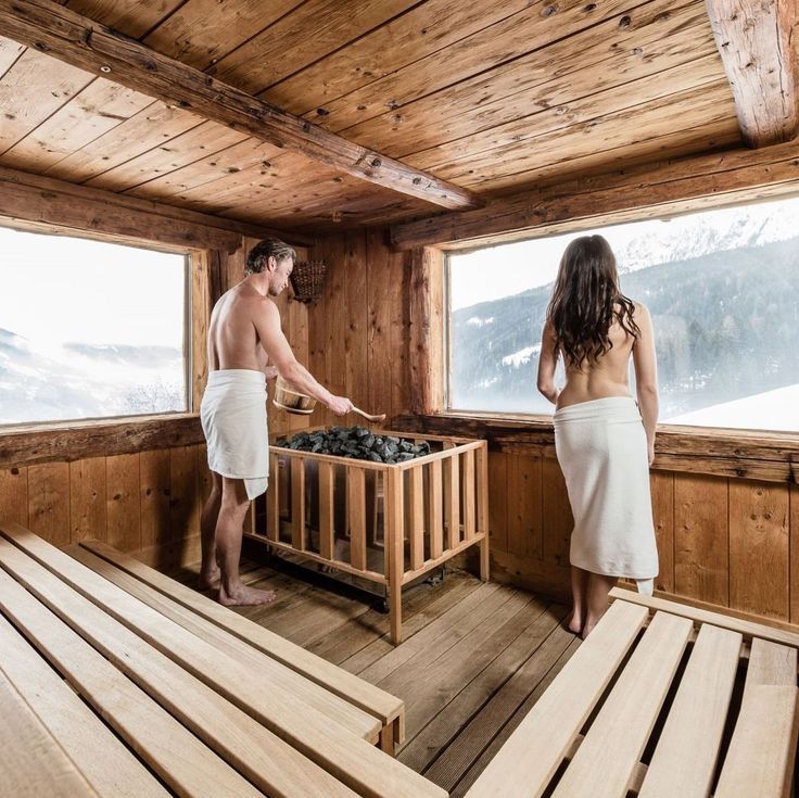 two people standing in a wooden sauna