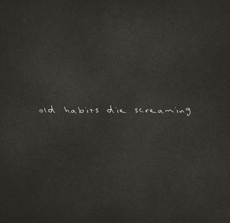 the words old habitts die screaming are written in white chalk on a black background