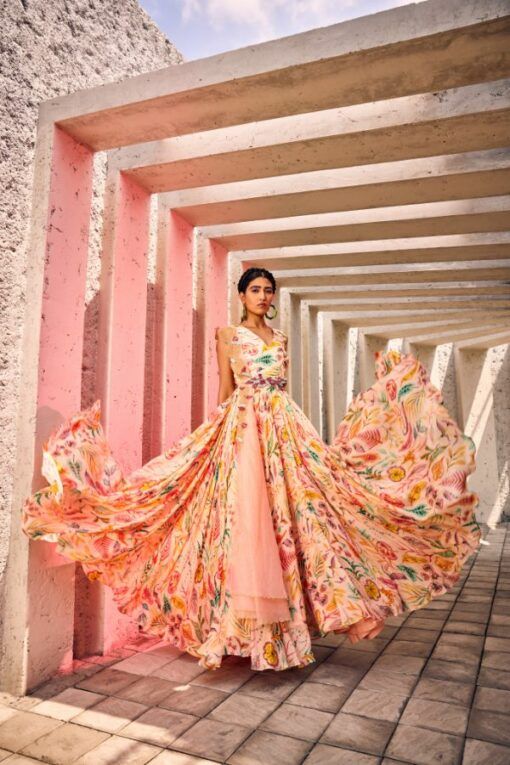 With the Printed Chic Gown, no detail is too small. This exquisite creation showcases expert tailoring, delicate embellishments, and luxurious fabrics, resulting in a piece that exudes refinement and luxury. The voluminous gown billows gracefully with every step, whilst the Heavy Belt accentuates the natural curves of the figure. The Dupatta adds an air of sophistication, flitting delicately with every movement. With its intricate print, this gown is the epitome of sophistication and charm. Off Shoulder Lehenga, Ruffle Lehenga, Raw Silk Lehenga, Gown With Dupatta, Mirror Work Blouse, Yellow Lehenga, Designer Lehengas, Ivory Blouse, Green Lehenga