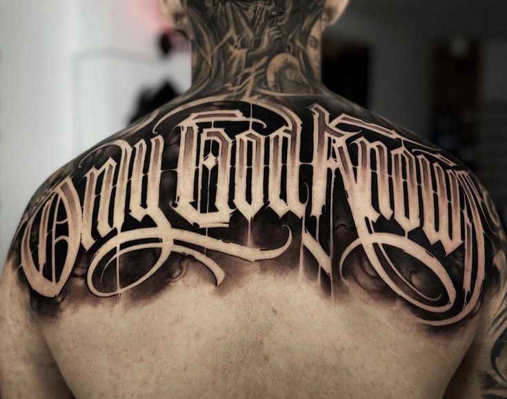 the back of a man's upper half with an old english tattoo on it