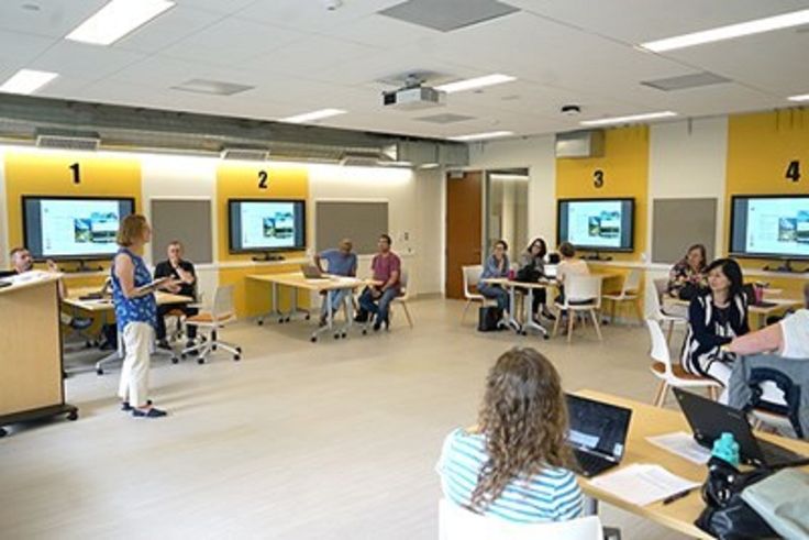 people are sitting at desks with laptops in front of them and on the screen