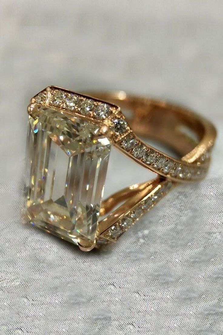 an engagement ring with a large diamond in the center and two rows of diamonds on each side