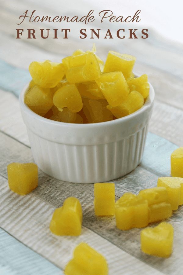 homemade peach fruit snacks in a small white bowl on a wooden table with text overlay