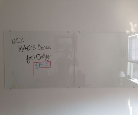 a whiteboard with writing written on it in an office space next to a window