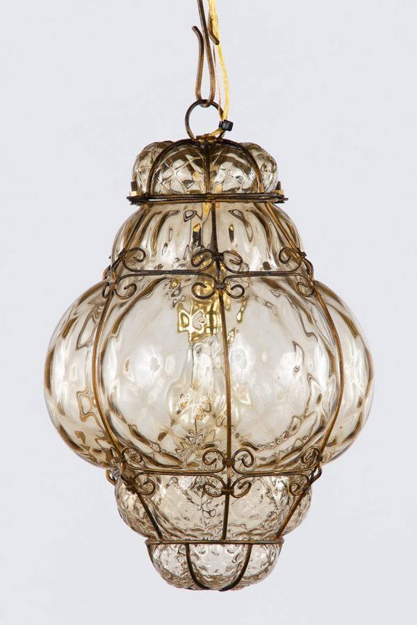 an old fashioned glass light hanging from a ceiling