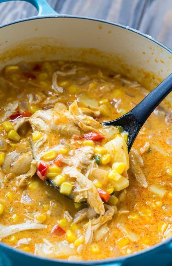 a blue pot filled with chicken and corn soup