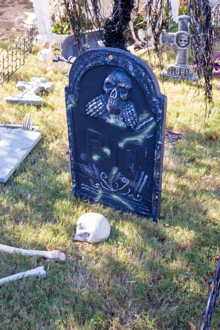 a cemetery with skulls and bones on the ground in front of it, next to a tombstone