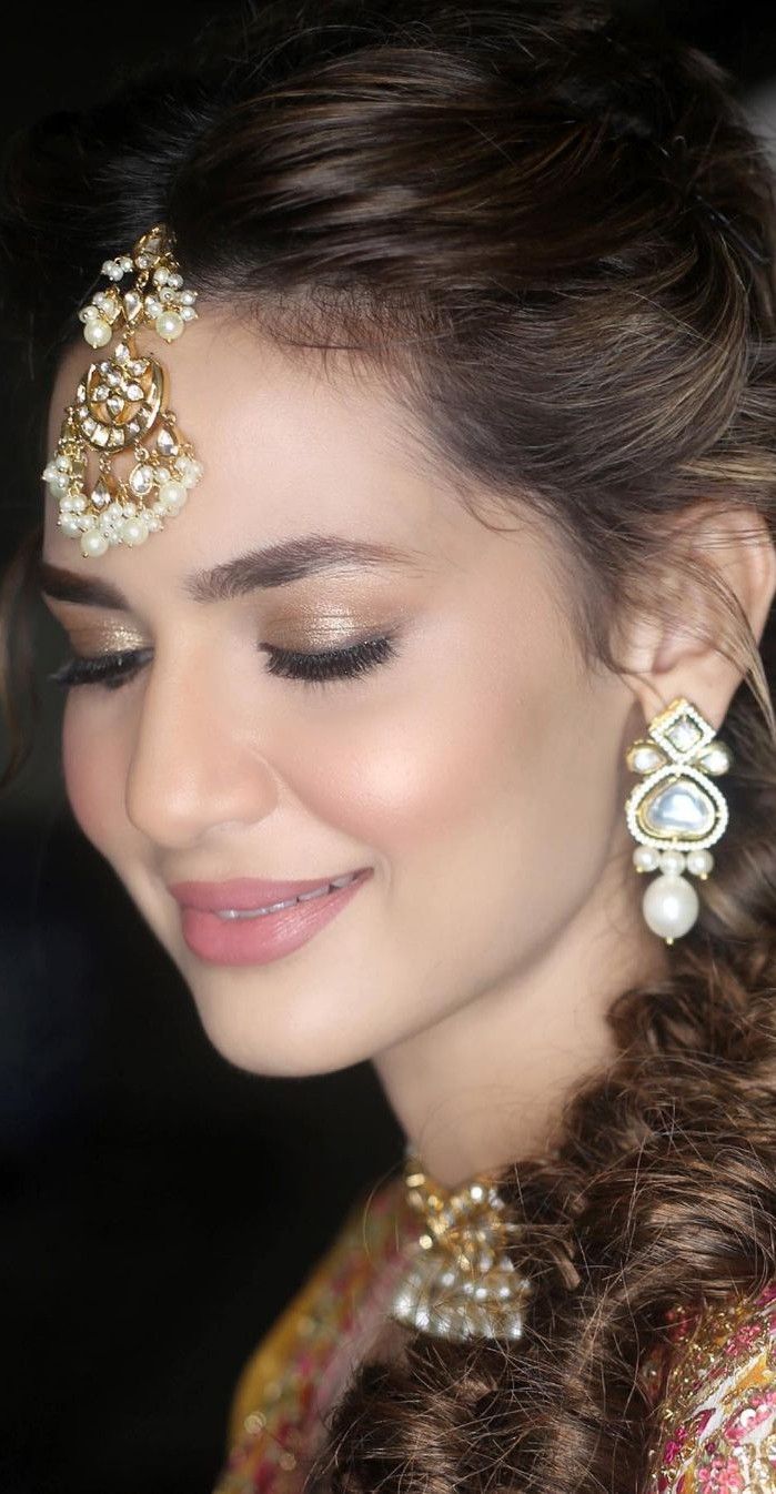 a woman in a bridal outfit with pearls on her head and hair pinned back to her face