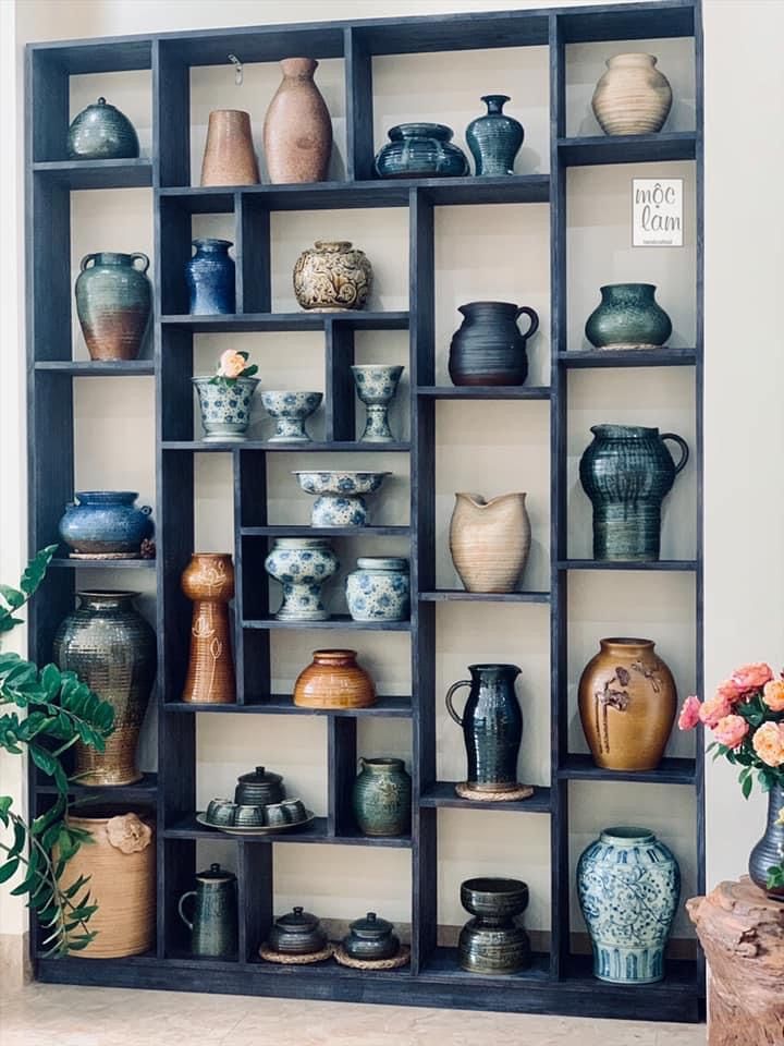 a shelf filled with vases and pots on top of it