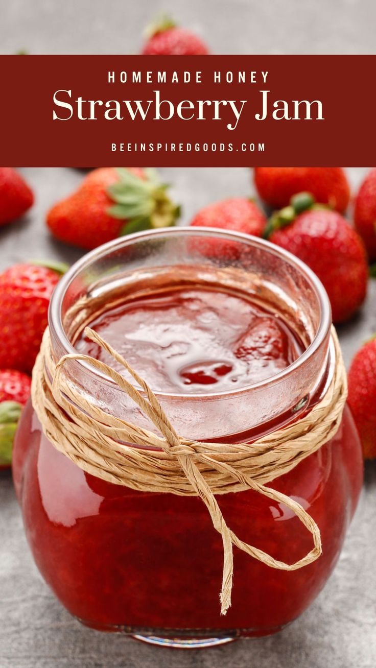 homemade honey strawberry jam in a glass jar with strawberries around it and text overlay reading homemade honey strawberry jam