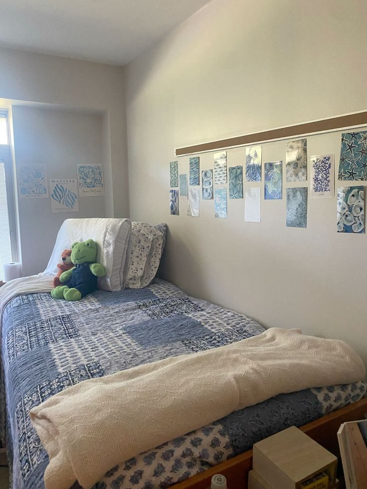 there is a stuffed animal on top of the small bed in this room with blue and white decor