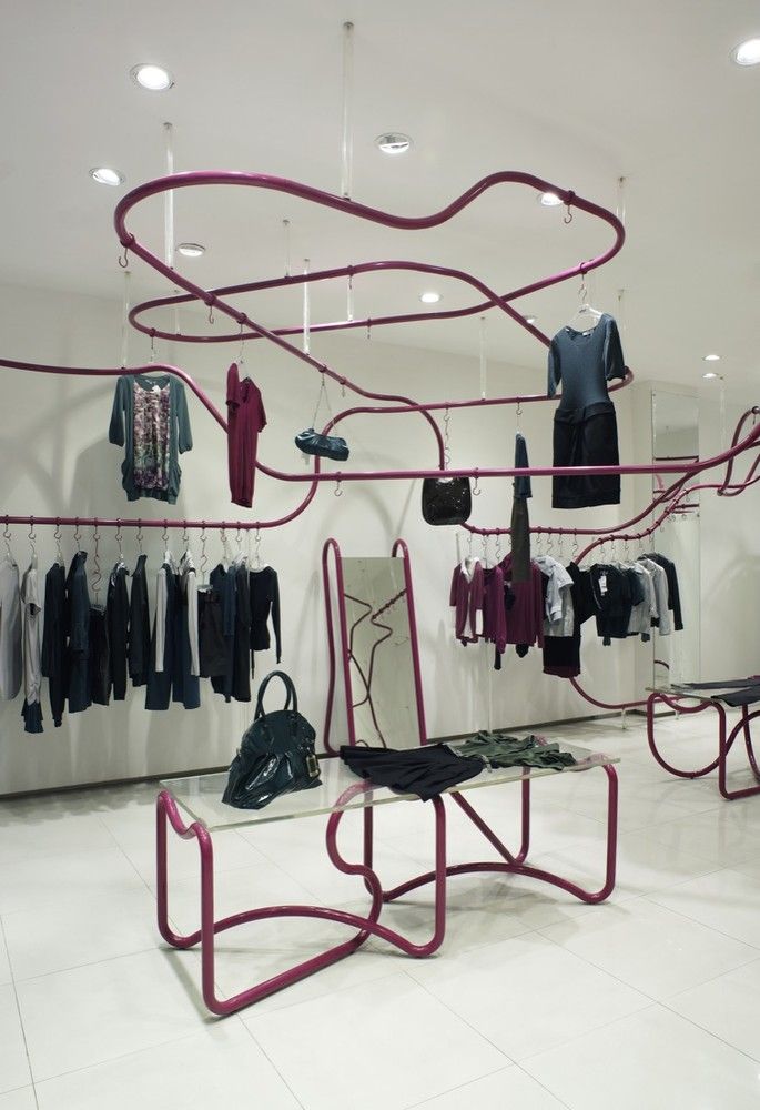 a clothing store display with clothes hanging on the rack and other items in front of it