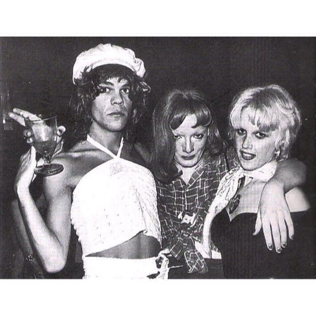 three women posing for the camera with one holding a drink