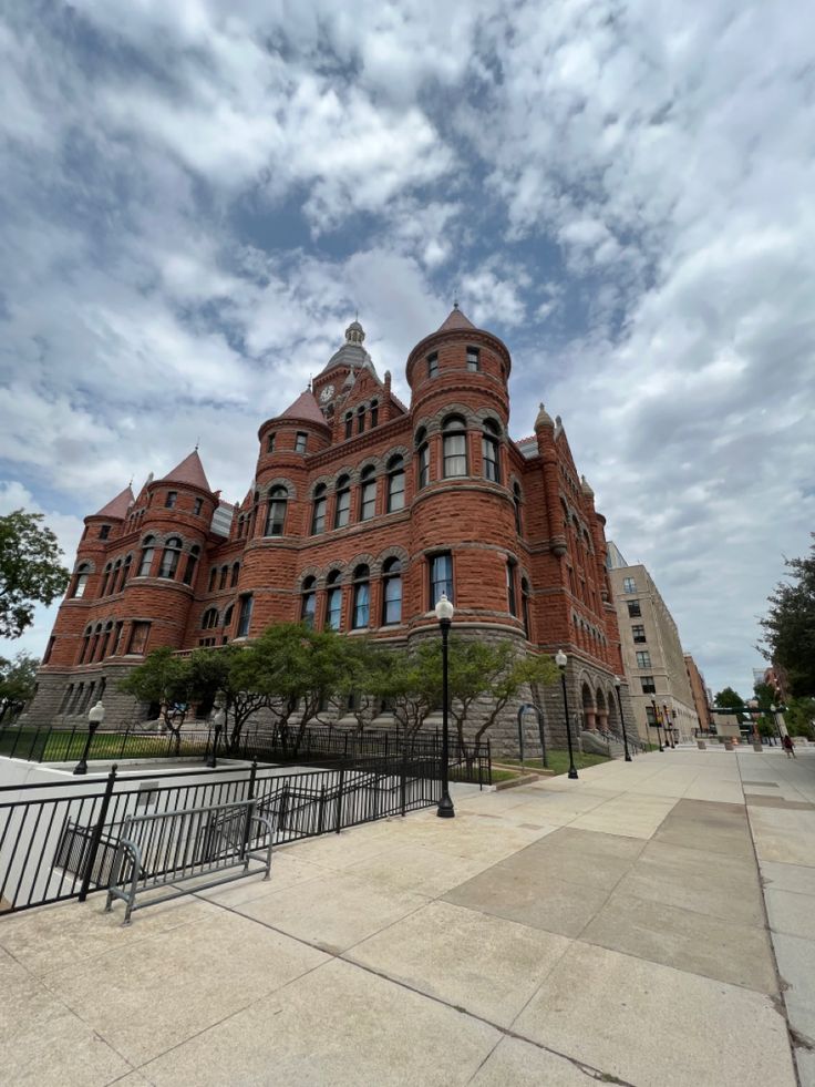 an old red brick building on a cloudy day