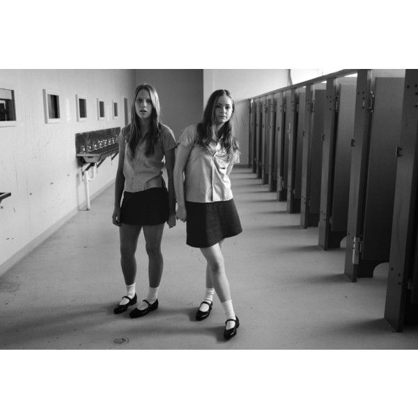 two girls standing in a hallway next to lockers with their hands on their hips