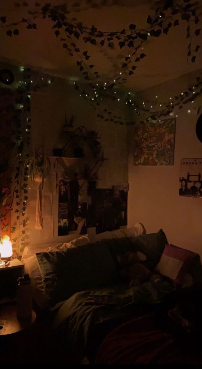 a living room filled with lots of furniture and lights hanging from the ceiling above it