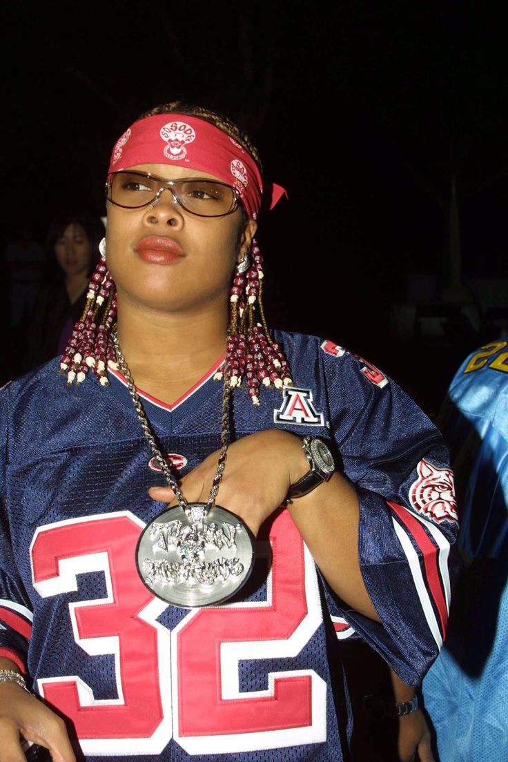 a woman in a football uniform holding a medal